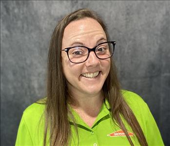 Female in lime green shirt standing in front of grey backdrop