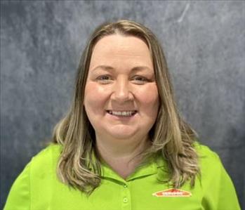 Female in lime green shirt standing in front of grey backdrop