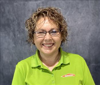 Female with glasses, wearing a lime green SERVPRO shirt, standing in front of grey backdrop